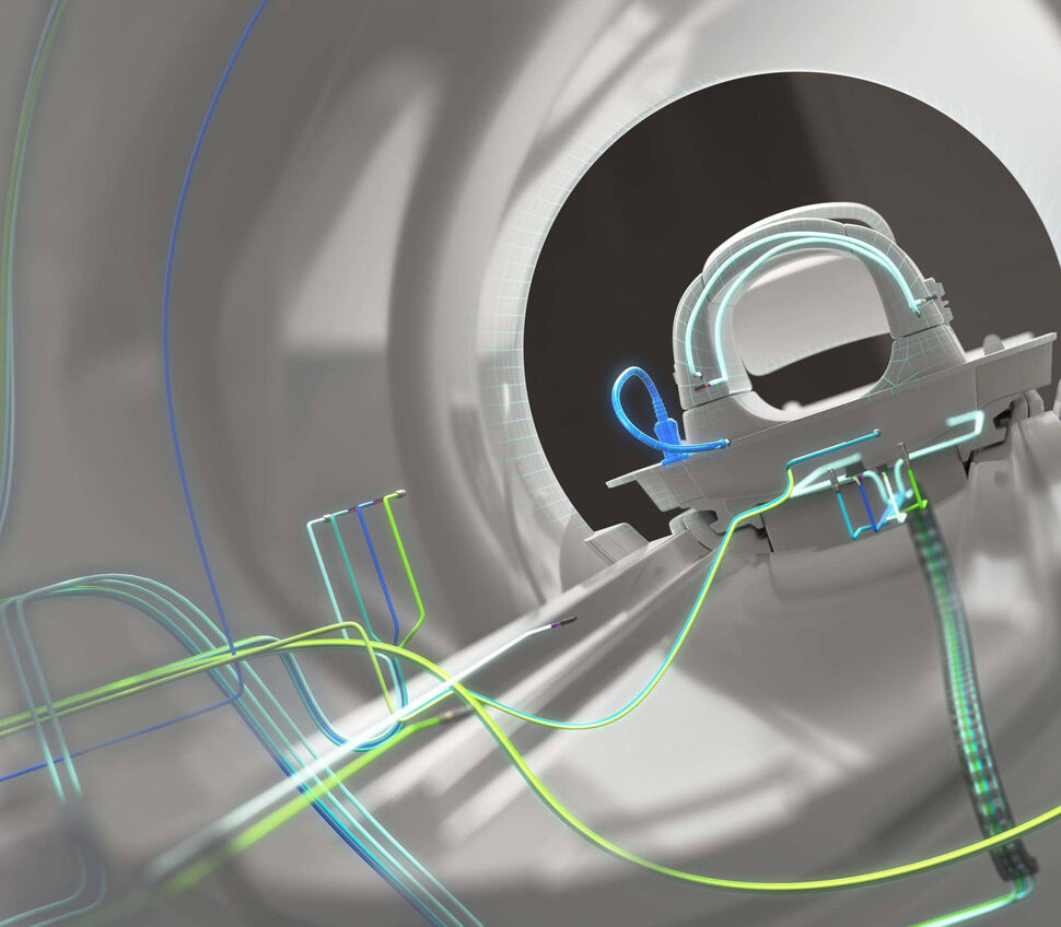 Zoom-in view through an MRI gantry with some exemplary cabling in the background.