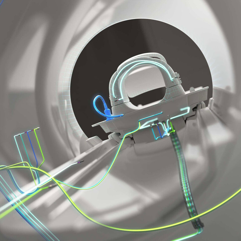 Zoom-in view through an MRI gantry with some exemplary cabling in the background.