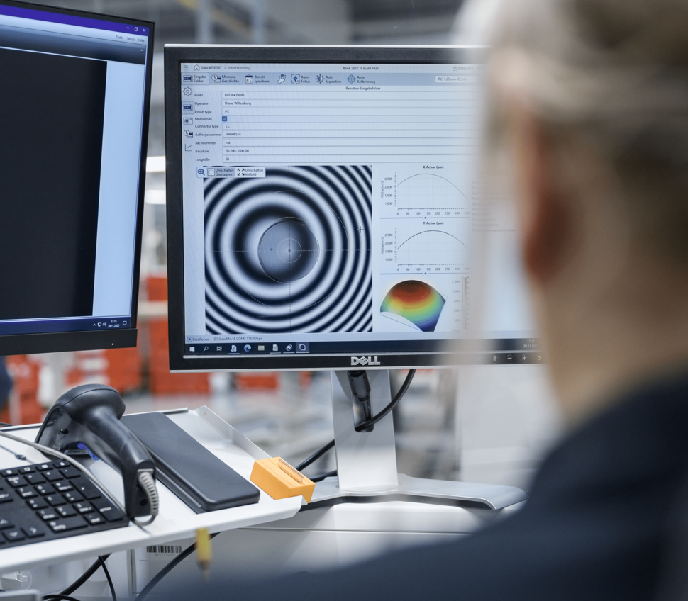 3D interferometer measurement of a fiber optic cable being analyzed by an employee.