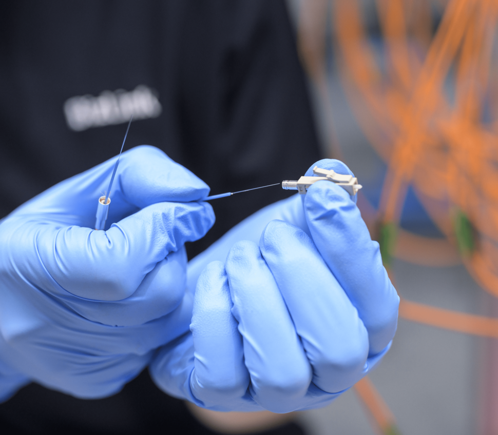 An employee inserts a fiber into an LC connector.