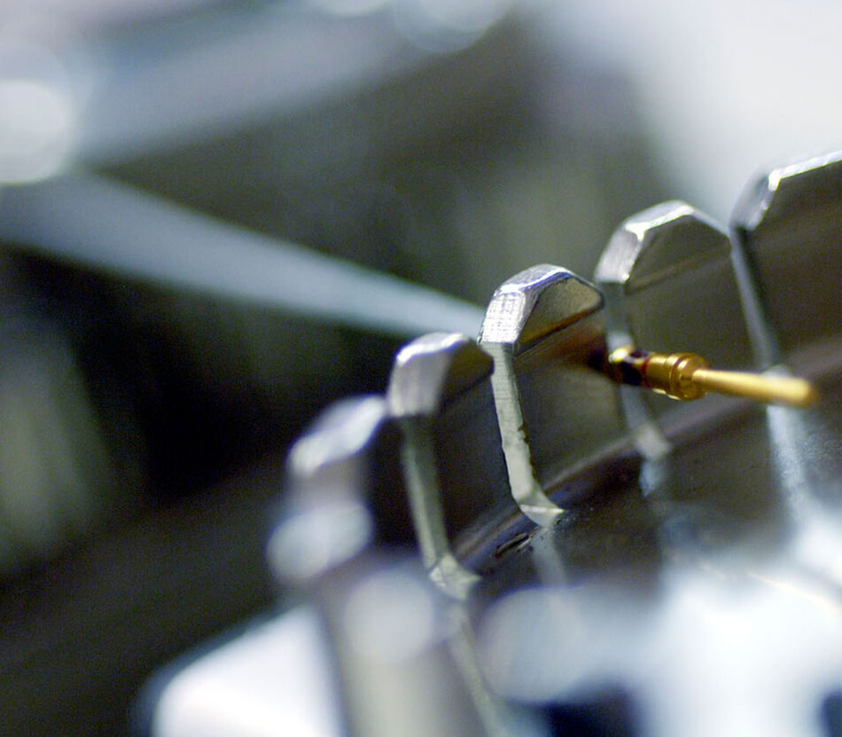 Tensile strength test machine with a crimped wire connected, showing the fixture used to apply uniform axial tension for quality testing.