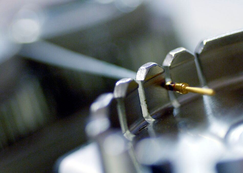 Tensile strength test machine with a crimped wire connected, showing the fixture used to apply uniform axial tension for quality testing.