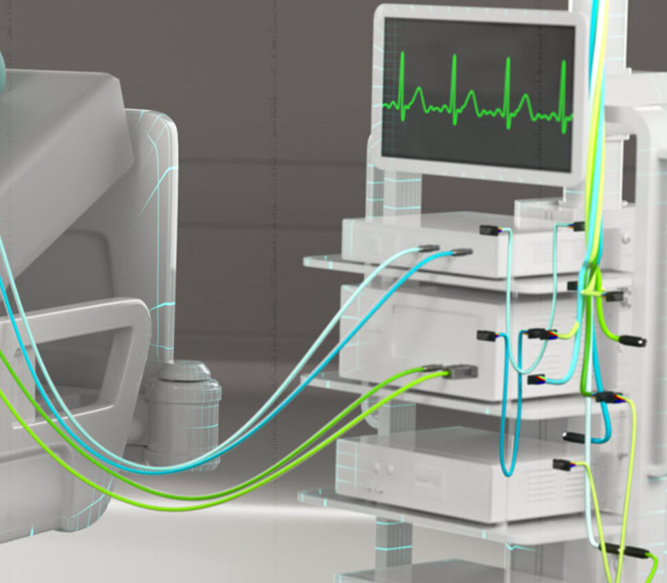 Patient monitoring unit next to person on patient bed with connected ECG and EEG cables